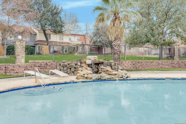 a front view of a house with a yard and swimming pool