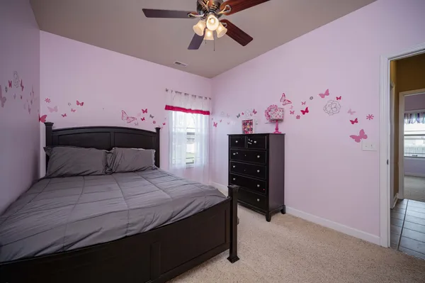 a spacious bedroom with a bed and a dresser