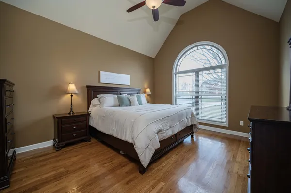 a bedroom with a bed and wooden floor