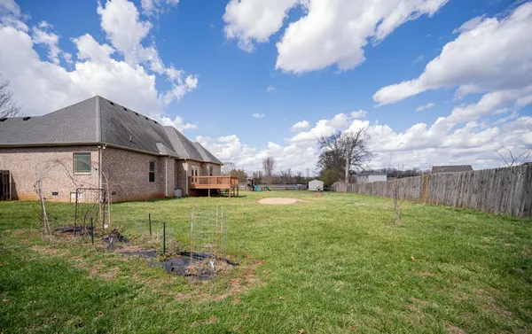 a view of backyard with wooden fence