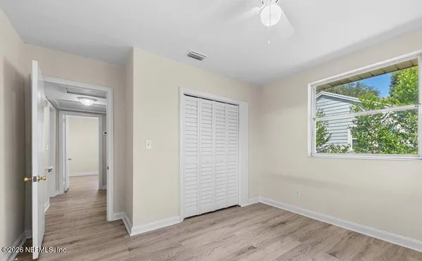 an empty room with wooden floor and windows
