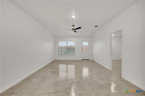 an empty room with a empty space and windows