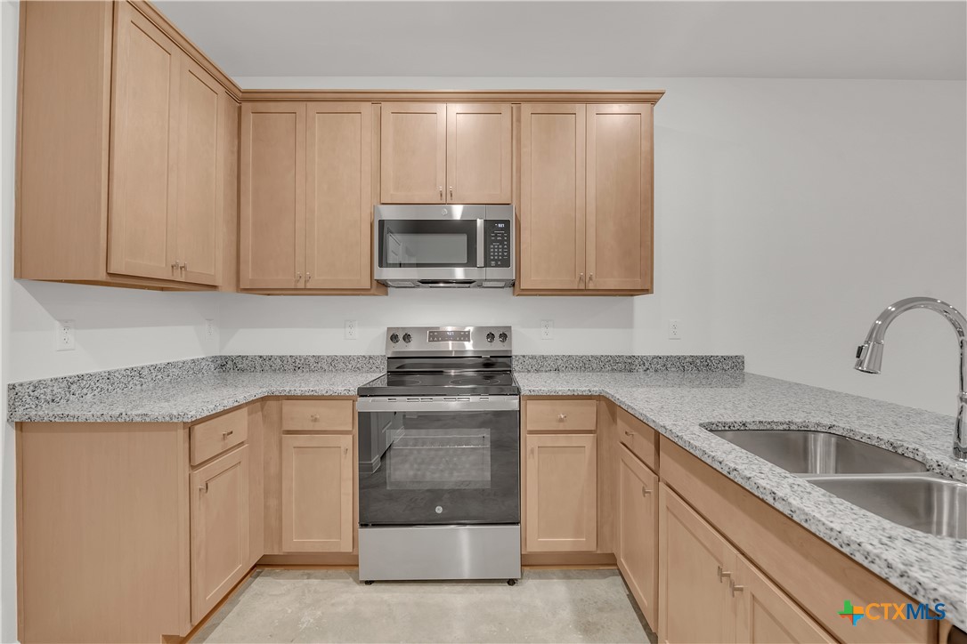 909 Wax Myrtle Court, Unit B Killeen, TX 76543 - Photo 7 of 15 a kitchen with white cabinets appliances and sink