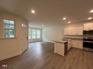 6419 Granite Quarry Drive Raleigh, NC 27610 - Photo 6 of 53 a kitchen with granite countertop a stove and a wooden floors
