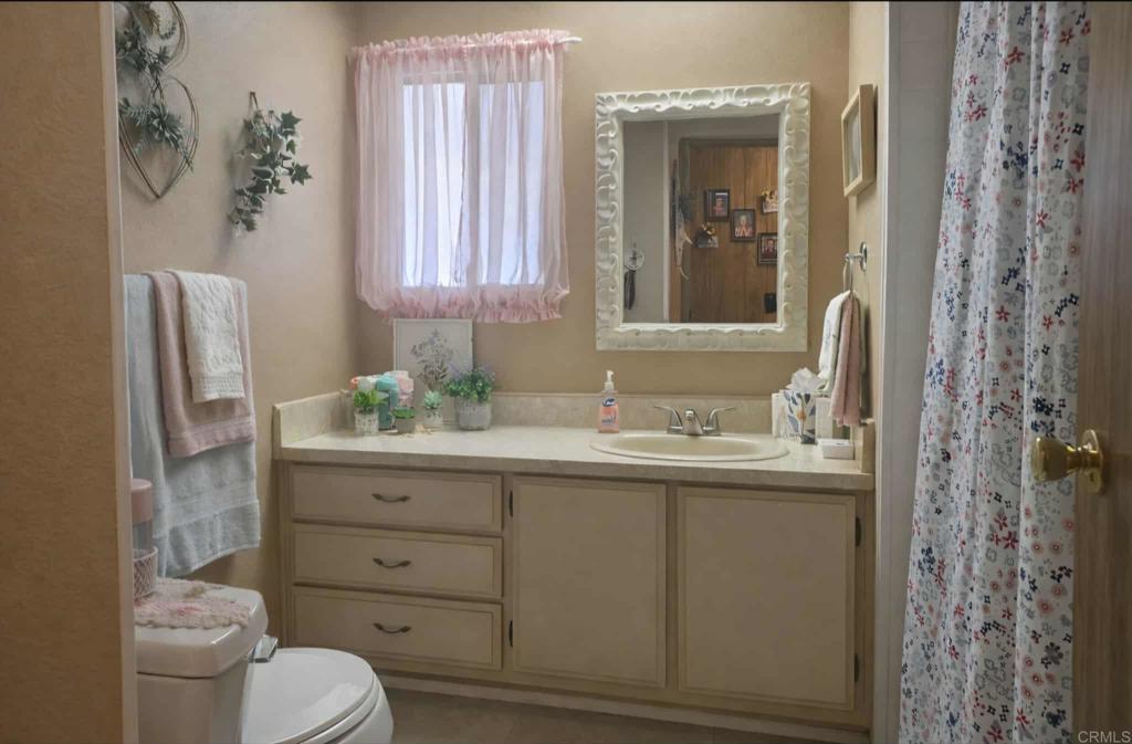 1815 Sweetwater, Unit 1 Spring Valley, CA 91977 - Photo 25 of 34 a bathroom with a granite countertop toilet sink and mirror