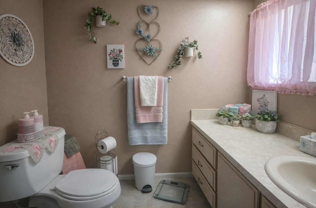 1815 Sweetwater, Unit 1 Spring Valley, CA 91977 - Photo 26 of 34 a bathroom with a granite countertop toilet sink and mirror