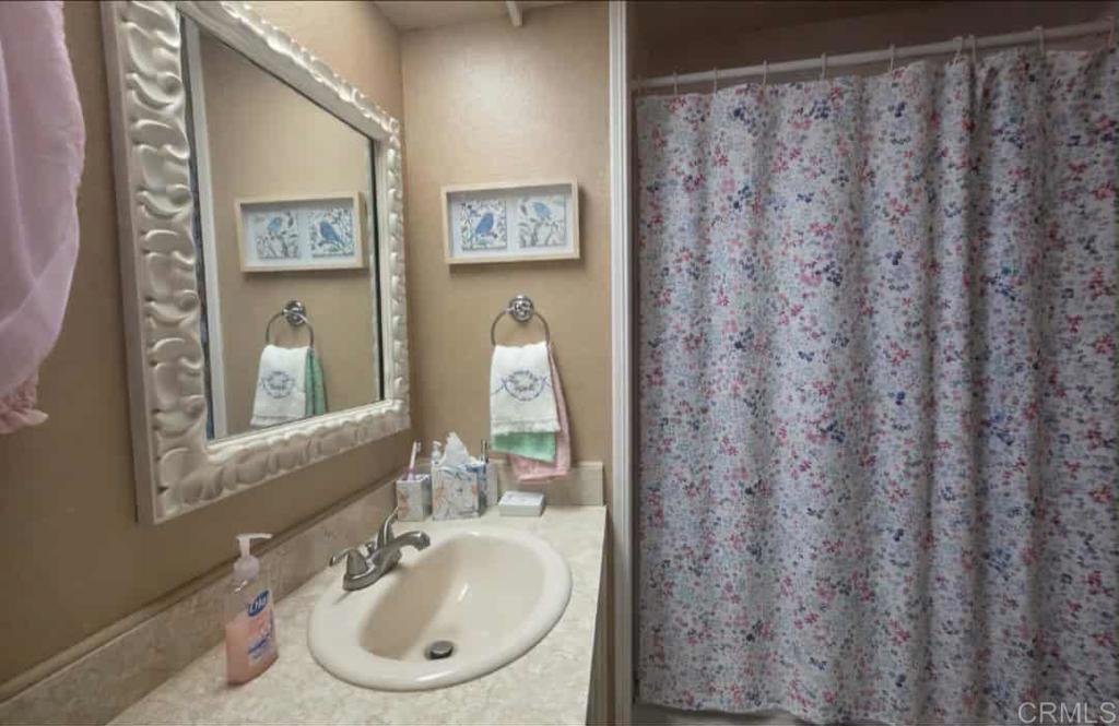 1815 Sweetwater, Unit 1 Spring Valley, CA 91977 - Photo 27 of 34 a bathroom with a sink and a mirror
