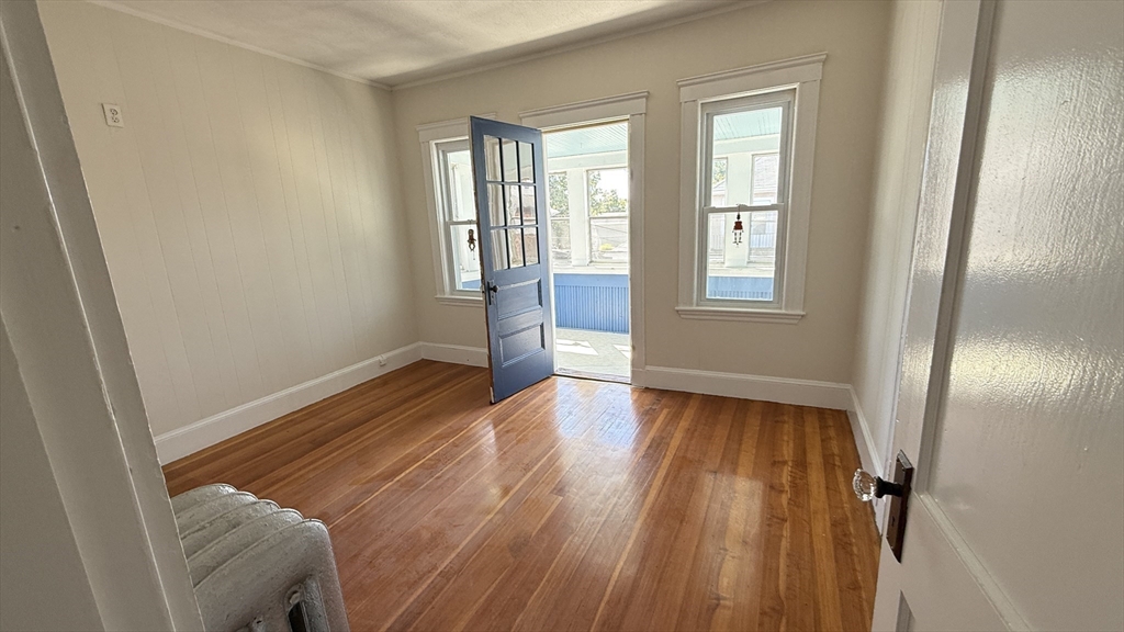 12 Eliot Street, Unit 12 Medford, MA 02155 - Photo 3 of 11 an empty room with wooden floor and windows