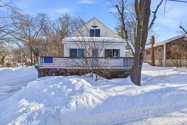 a view of a house with a yard covered in snow
