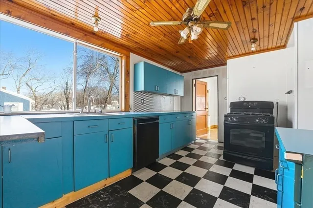 a kitchen with a refrigerator and wooden cabinets