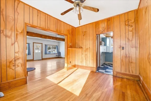 a view of a livingroom with wooden floor and a ceiling fan