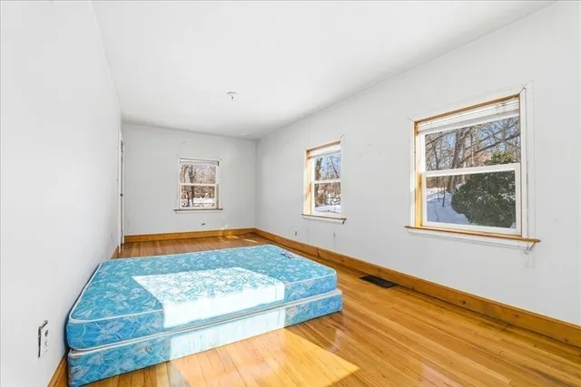 a bedroom with natural light and wooden floor