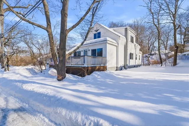 a view of a house with a yard covered in snow