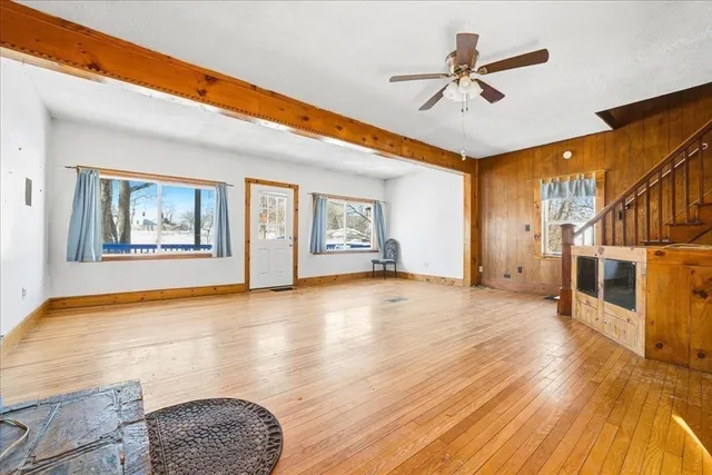 a view of an empty room with window and wooden floor