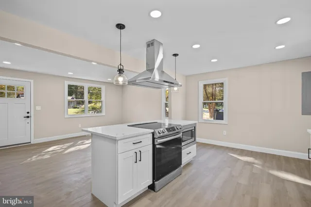 a open kitchen with stainless steel appliances granite countertop a sink a stove a refrigerator and a window