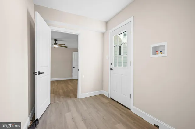 an empty room with wooden floor mirror and windows