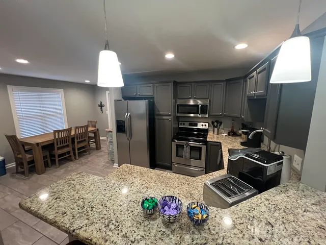 a kitchen with refrigerator and chairs
