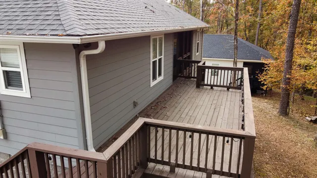 a view of a house with wooden deck and furniture