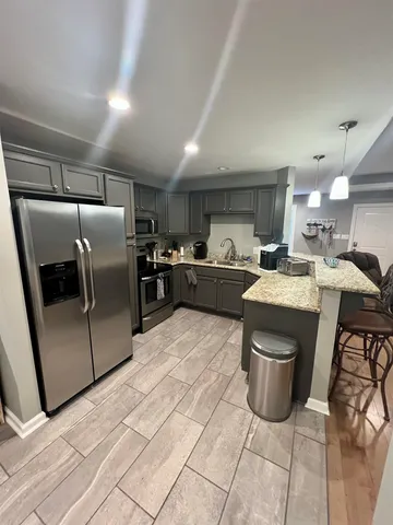 a kitchen with stainless steel appliances a sink a stove a refrigerator and cabinets