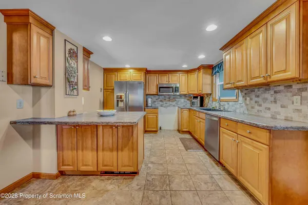 a kitchen with stainless steel appliances granite countertop wooden cabinets a sink and dishwasher