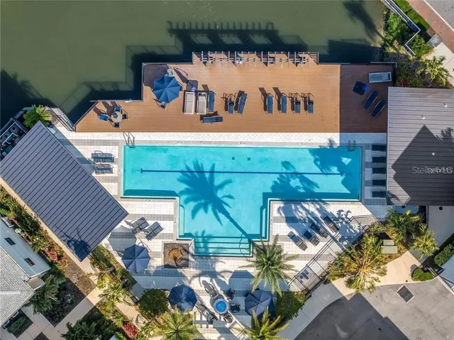 a kitchen with stainless steel appliances granite countertop a stove a refrigerator a sink dishwasher a dining table and chairs with wooden floor