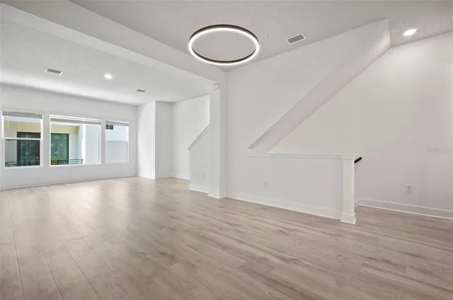 a view of a big room with wooden floors and windows