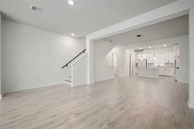 a large kitchen with cabinets wooden floor and stainless steel appliances