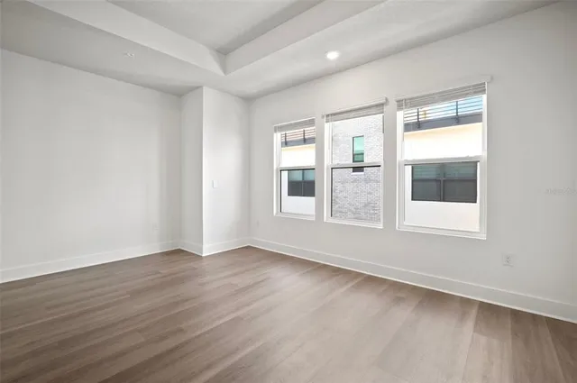 a view of an empty room with wooden floor