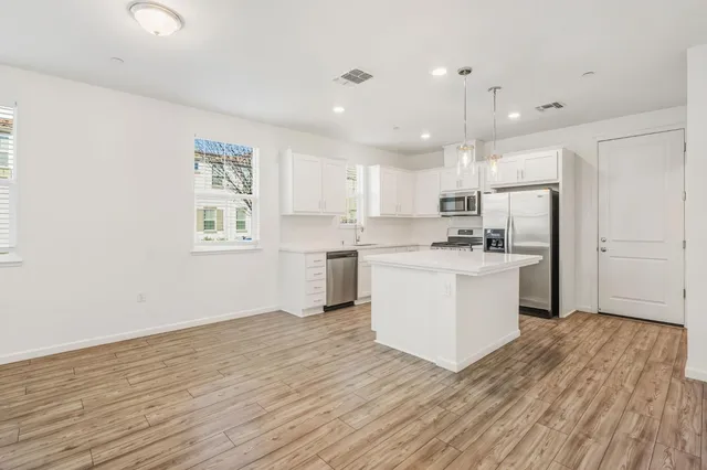 a view of kitchen with wooden floor and electronic appliances