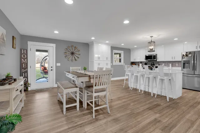 a view of a dining room with furniture wooden floor and a kitchen