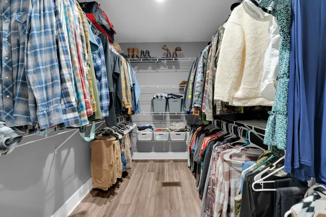 a view of walk in closet with clothes and shoes