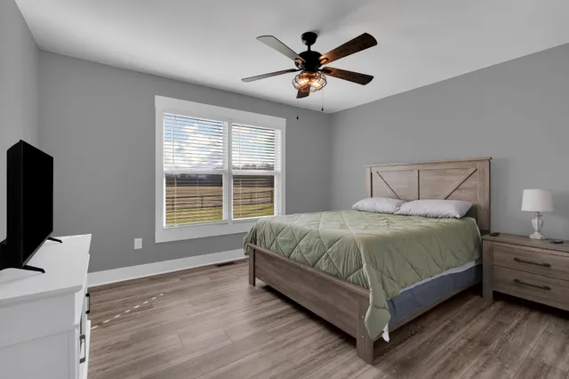 a bedroom with a large bed and a flat tv screen on dresser
