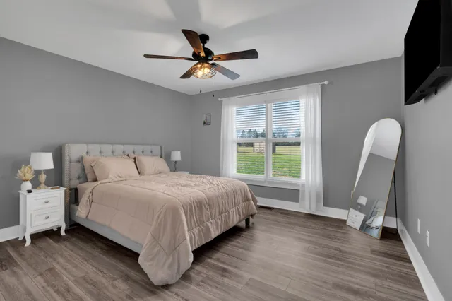 a bedroom with a bed a flat screen tv and a window