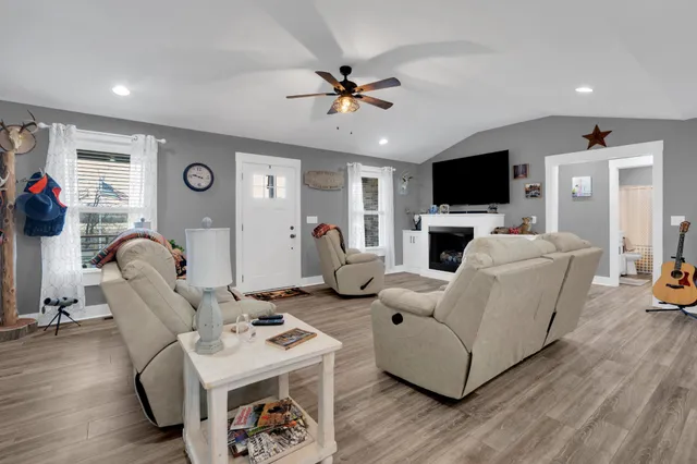 a living room with furniture a flat screen tv and a window