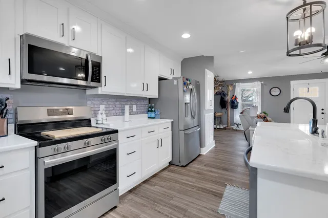 a kitchen with stainless steel appliances a stove microwave and refrigerator