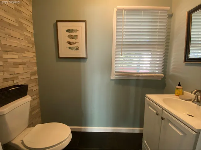 a bathroom with a toilet a sink and a window