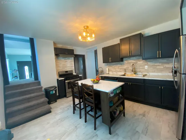 a kitchen with stainless steel appliances wooden floor dining table and chairs