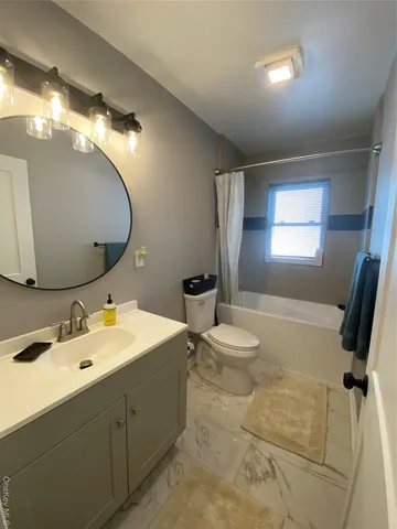a bathroom with a double vanity sink and mirror with toilet