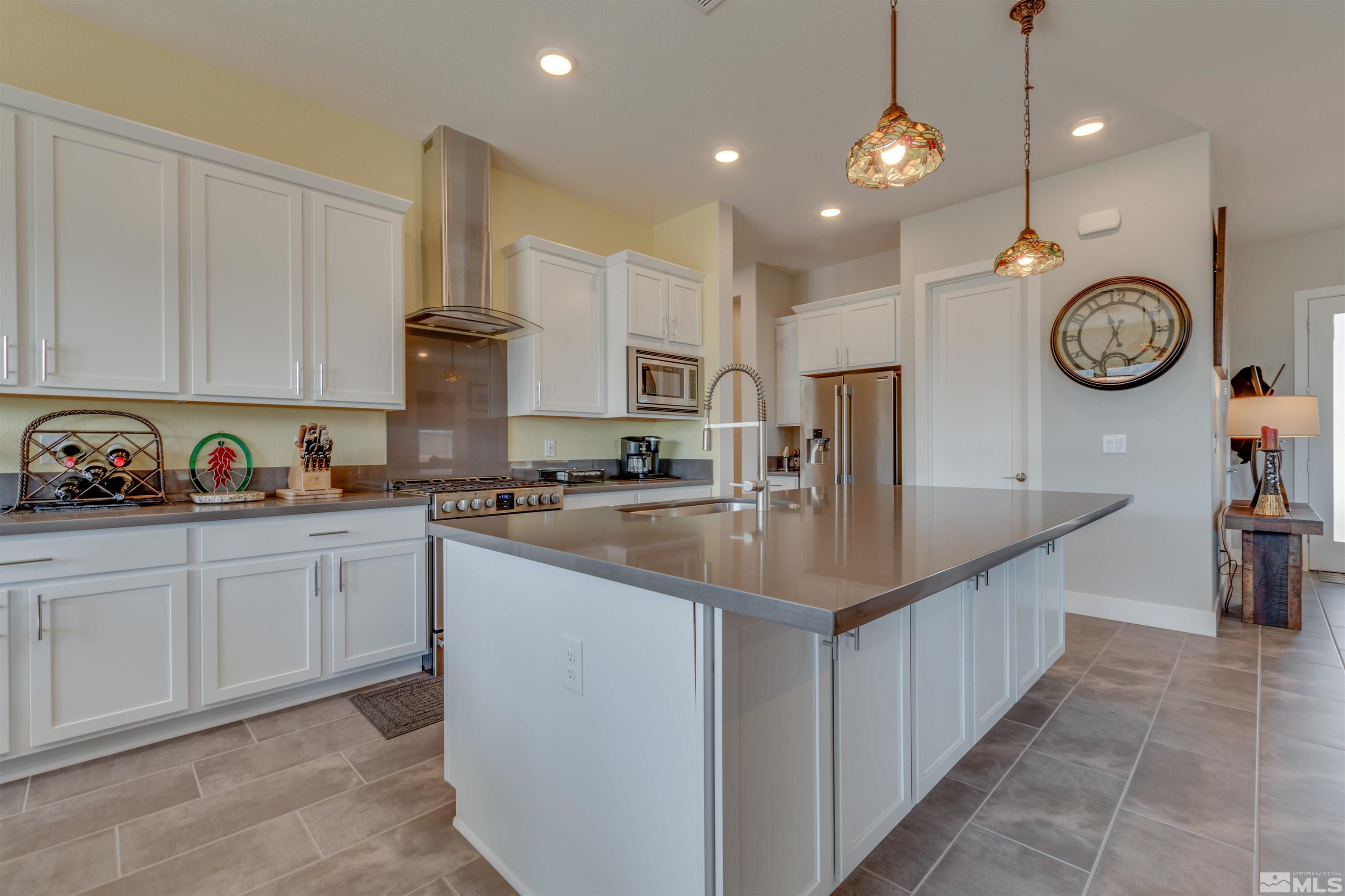 8718 Larkhaven Trail Reno, NV 89523 - Photo 7 of 39 a kitchen with kitchen island granite countertop a sink a stove and cabinets
