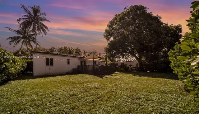 a view of a house with a yard and sitting area
