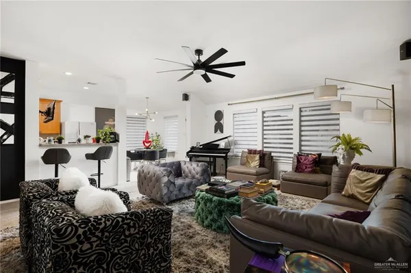 a living room with furniture floor to ceiling window and a flat screen tv
