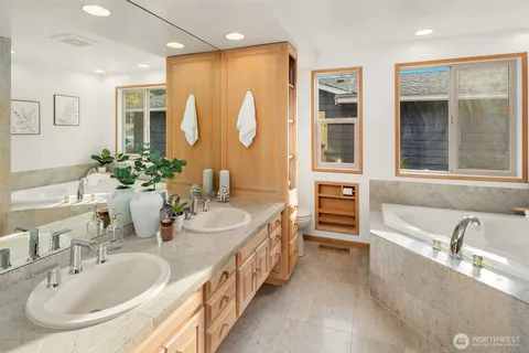 a bathroom with a granite countertop tub sink and mirror