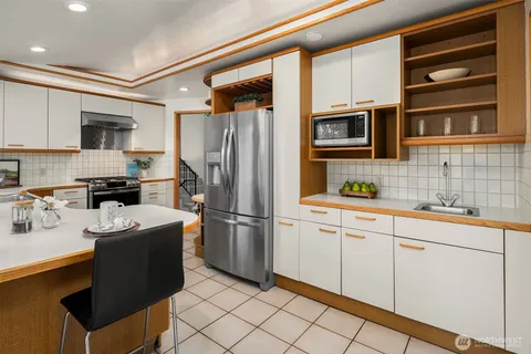a kitchen with stainless steel appliances granite countertop a refrigerator sink stove microwave and cabinets