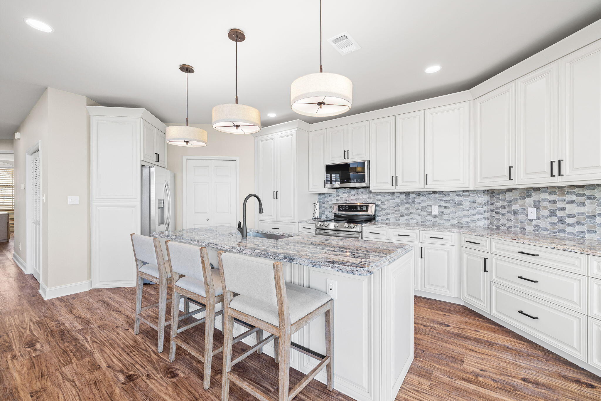 969 Northshore Drive Miramar Beach, FL 32550 - Photo 7 of 87 a kitchen with stainless steel appliances kitchen island granite countertop a sink a stove a dining table and chairs with wooden floor