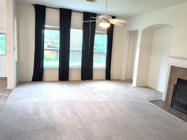 an empty room with windows and a fireplace