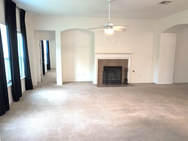 an empty room with fireplace and windows