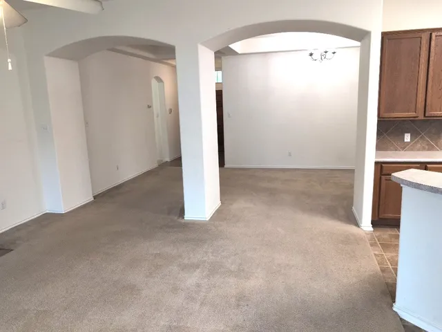 en empty room with windows and ceiling fan