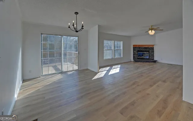wooden floor fireplace and windows in an empty room
