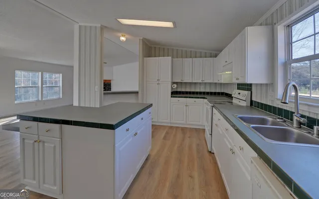 a kitchen with granite countertop a sink stove and cabinets
