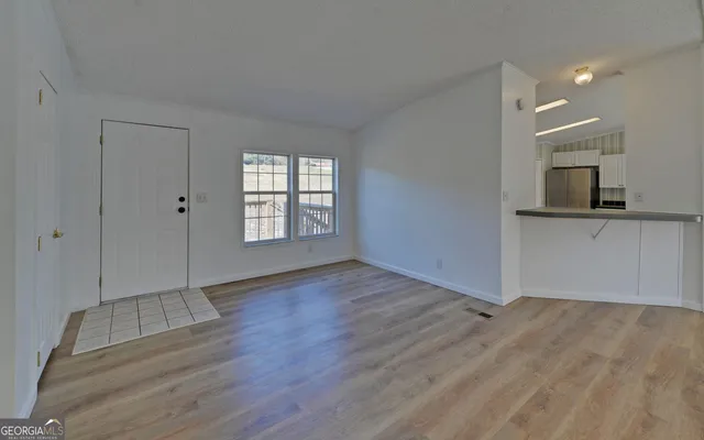 an empty room with wooden floor and a fireplace